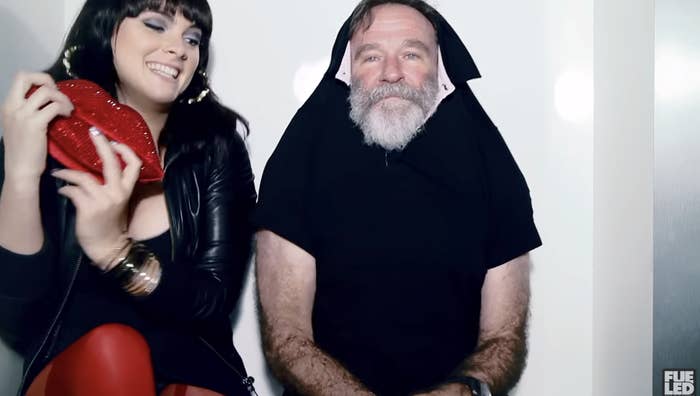 Robin next to a woman in a photo booth with his short over his ears.