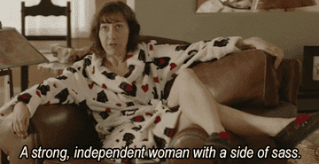 A woman sitting the couch saying &quot;[I&#x27;m] a strong independent woman with a side of sass.&quot;