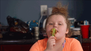 Honey Boo Boo licking peanut butter off a stick of celery.
