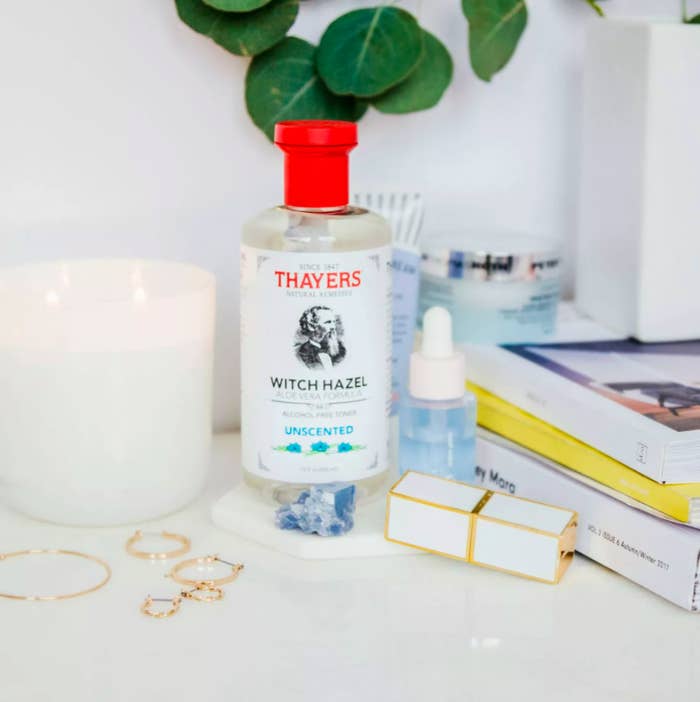 the unscented toner displayed on a desk next to a candle