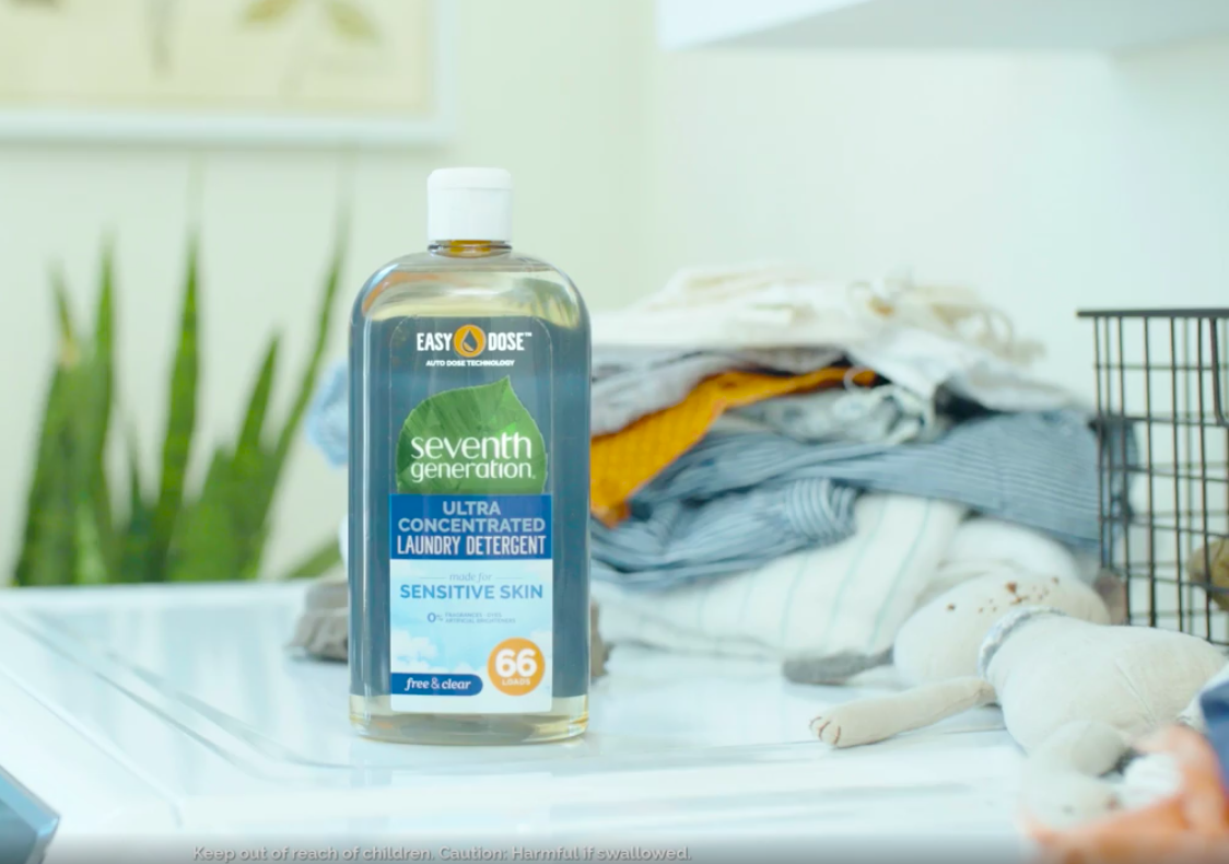 the laundry detergent with a squirt-bottle top seen on top of a washer