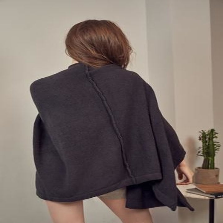 Model wearing robe in black, showing stylish exposed seams in back