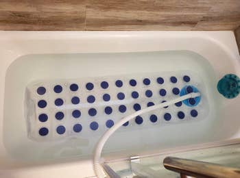 Reviewer's bath with bubble massage mat suction cupped to bottom of tub. 