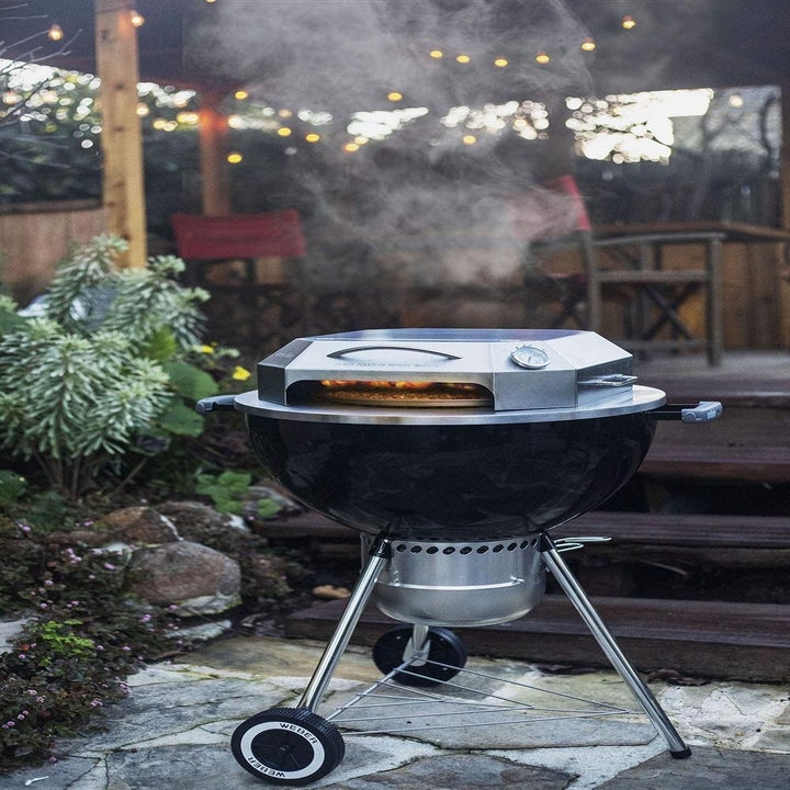 A grill with the pizza oven topper.