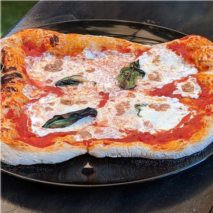 A pizza fresh out of the steel pizza oven.