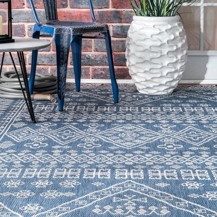 The blue and white patterned outdoor rug on a terrace.