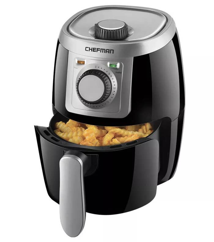 A black air fryer with crinkle-cut french fries in the basket