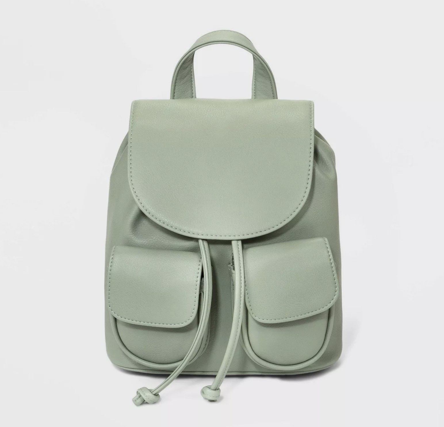 A mint green mini backpack with a flap opening and two pockets in the front