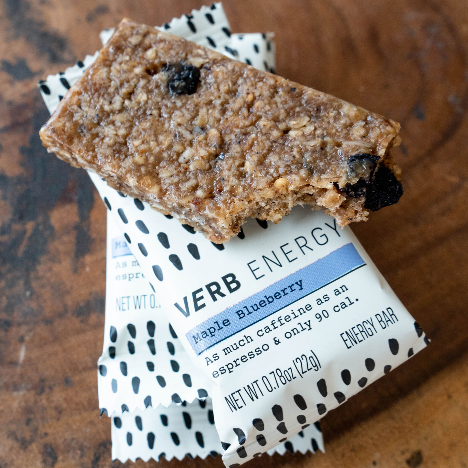 A blueberry oat bar on top of a packaged bar