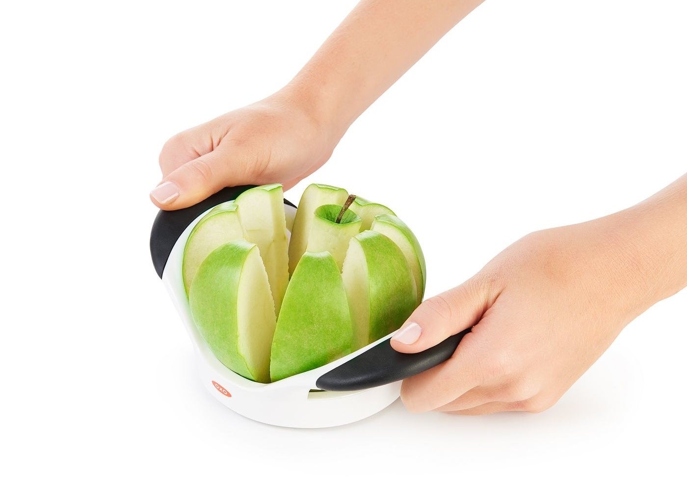 person using an oxo apple slicer to prepare a green apple