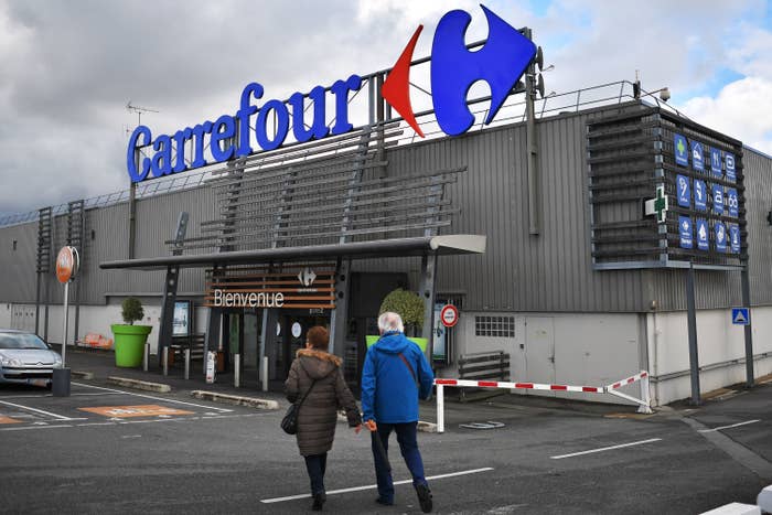 A couple walking into a Carrefour supermarket