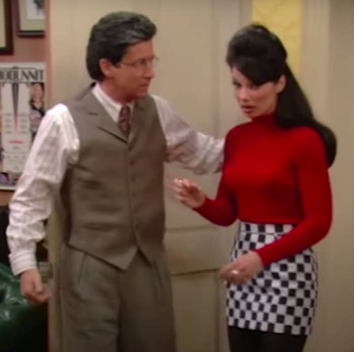 Fran Fine, wearing a black and white checkered mini skirt paired with a red turtleneck, talking to Mr. Sheffield.