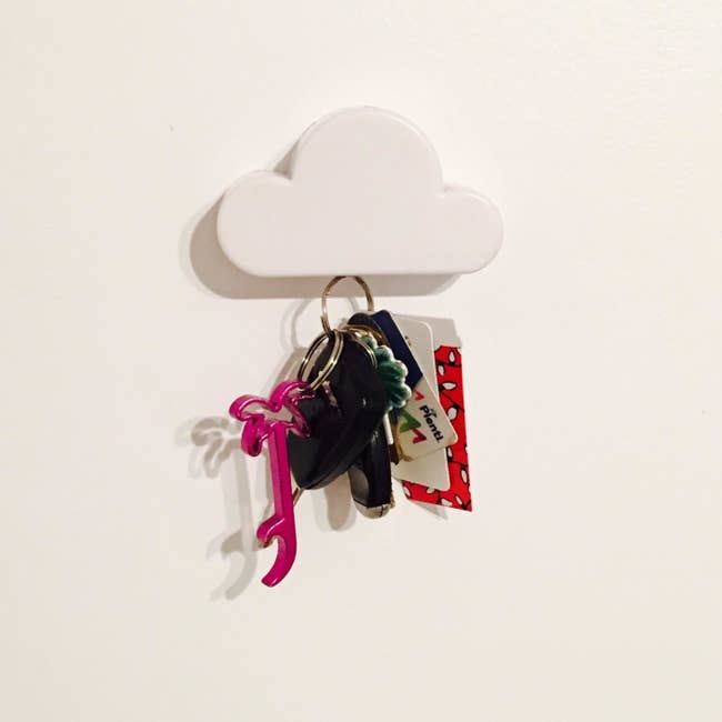 Reviewer pic of the white cloud key holder attached to the wall with a big set of keys hanging from it.
