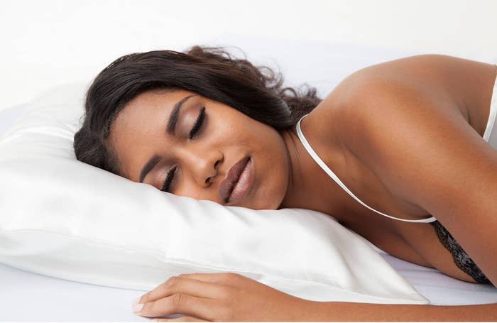 person sleeping on a white satin pillowcase