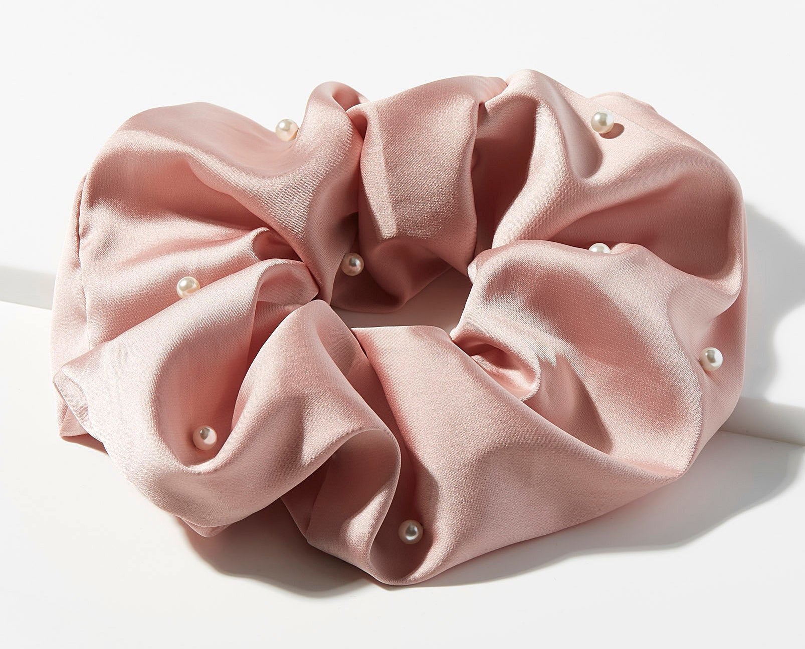 A large silk hair scrunchie with pearls on it