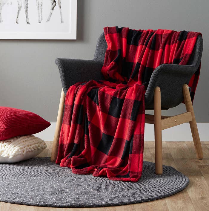 A soft throw blanket is draped over a wooden chair
