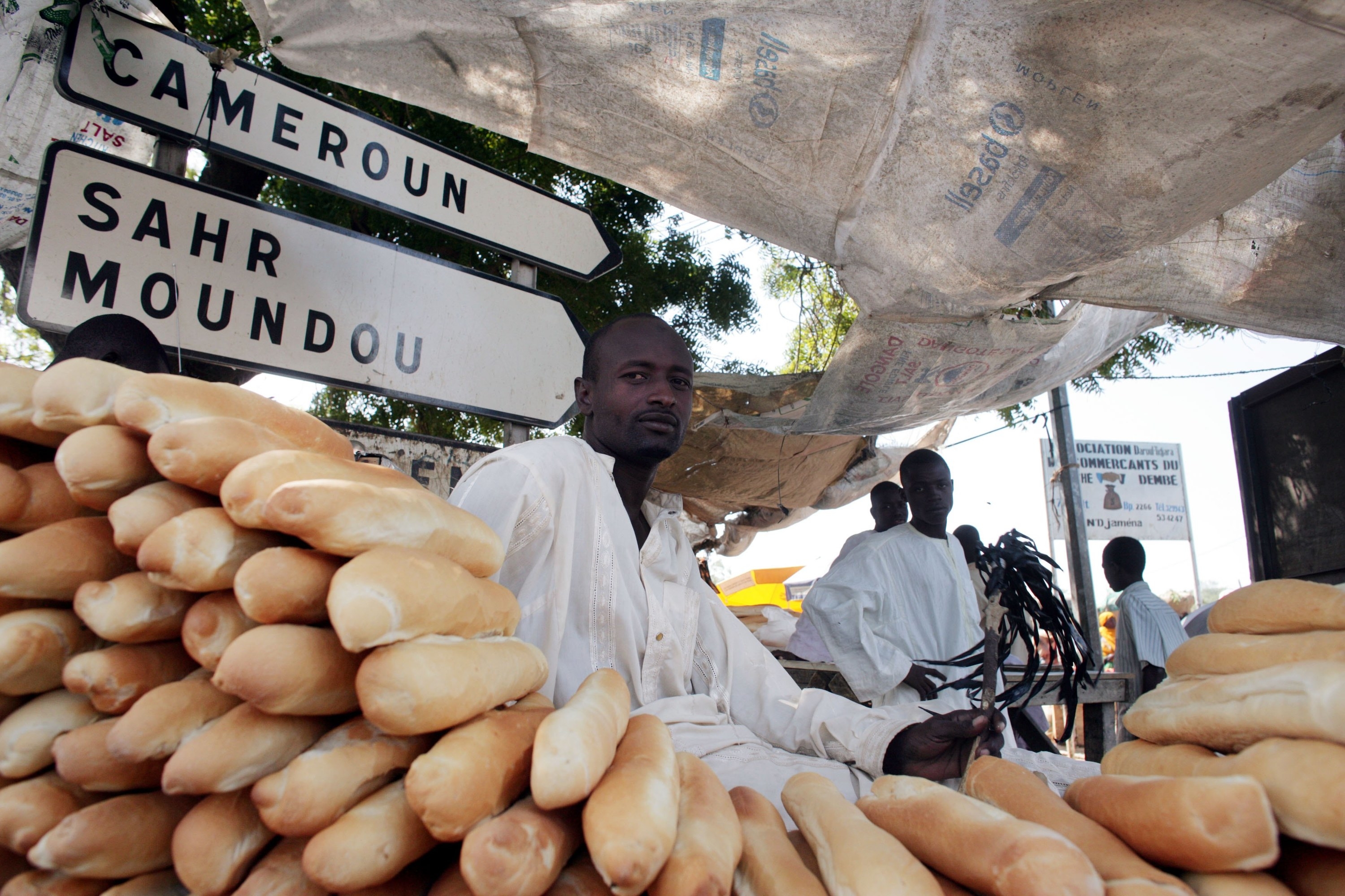 A bread stall and the vendor at an open-air market