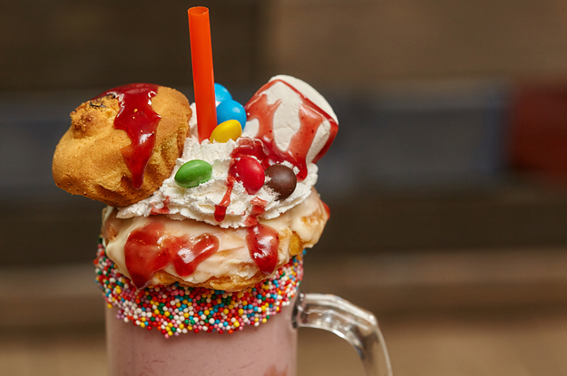 Monster milkshake topped with marshmallows whipped cream candy and baked goods