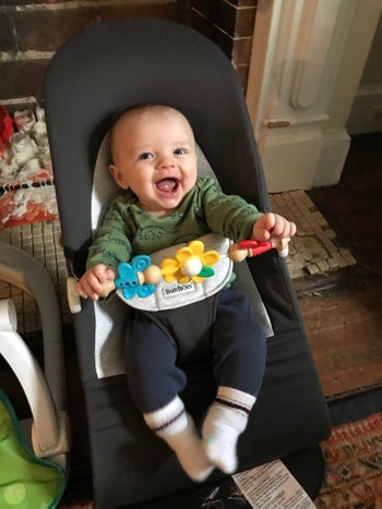 A cute baby smiles in his bouncer