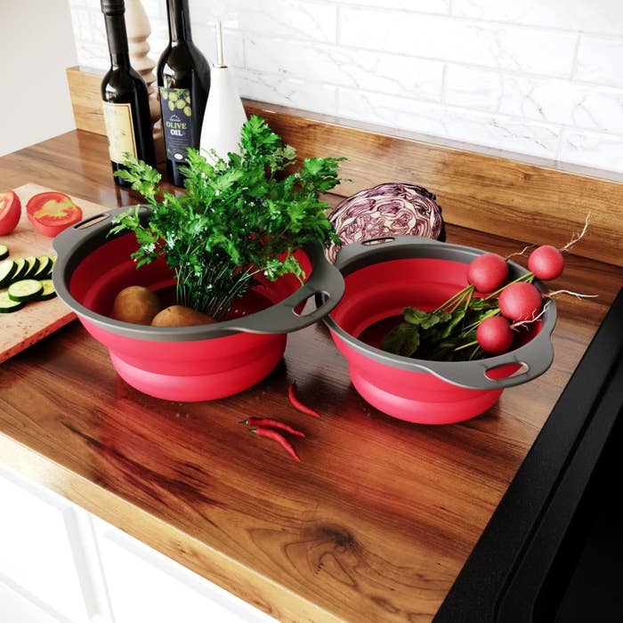 Two collapsible colanders filled with veggies