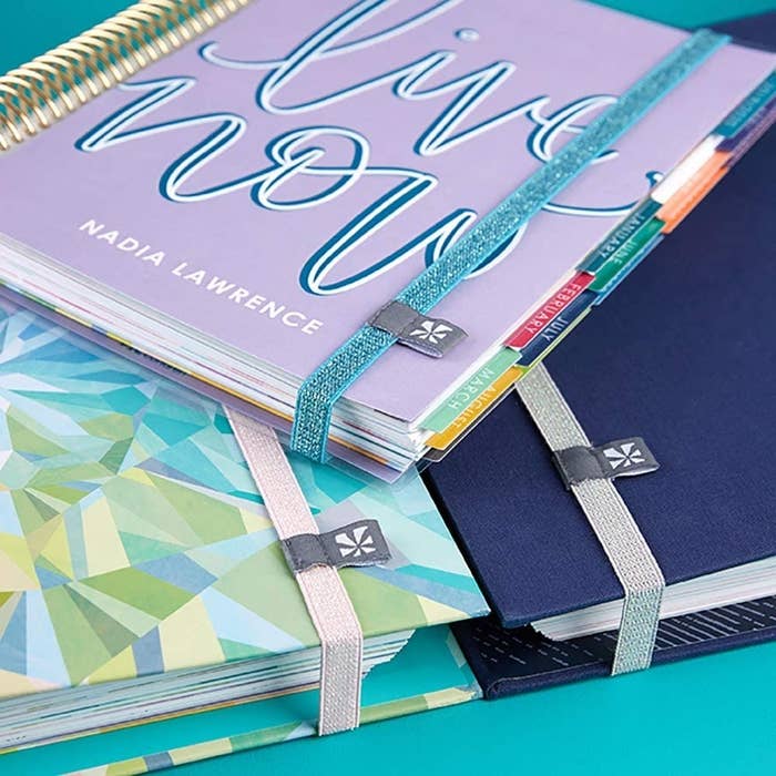 Three planners held together with the elastic bands