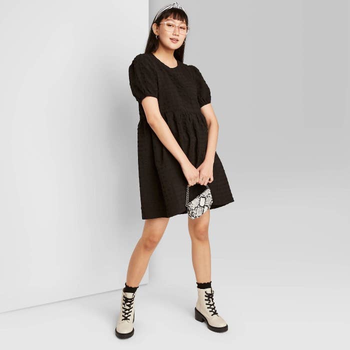 Model in short, puff sleeve black dress