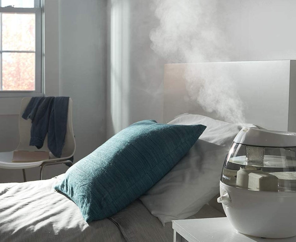 The humidifier on a nightstand, gently misting the room