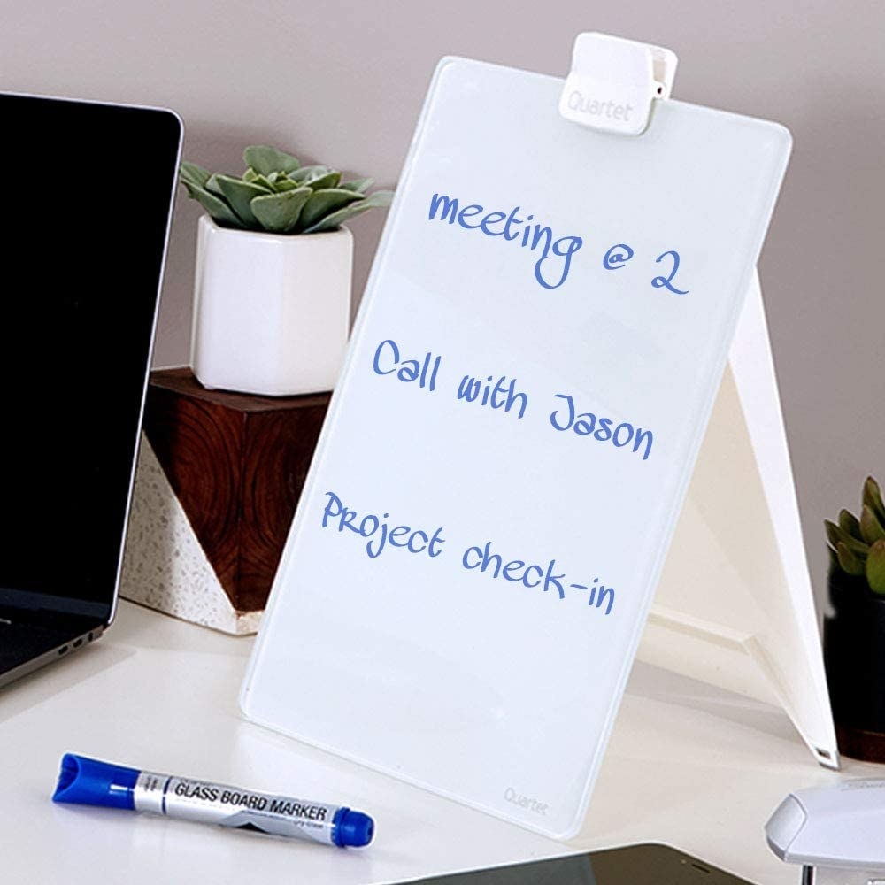 The dry-erase easel on a desk with a marker in front of it