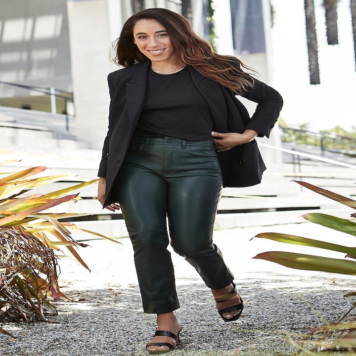 A model wearing the high-waisted slim pants with a black blazer, top, and sandals