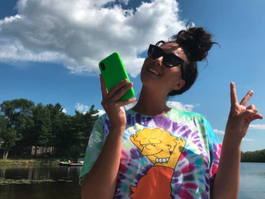 Liza holding her phone which has a neon green case