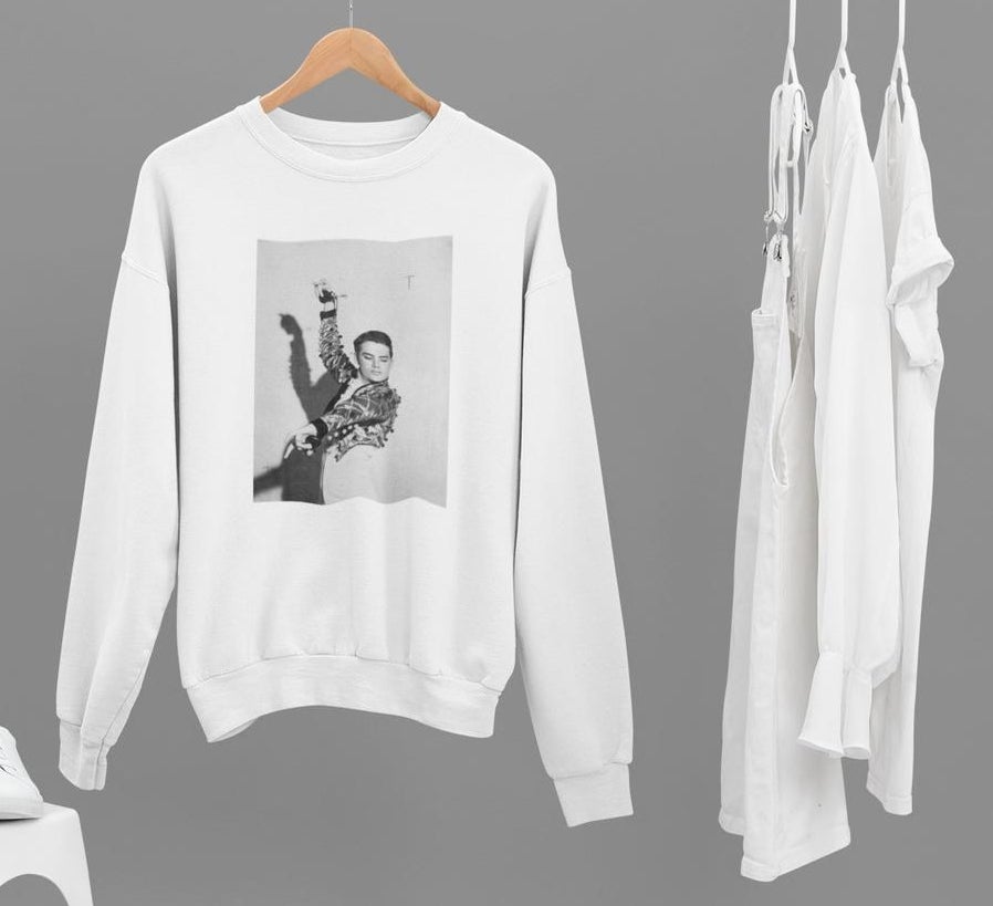 A white long sleeve sweatshirt with a black and white photo of a young Walter Mercado