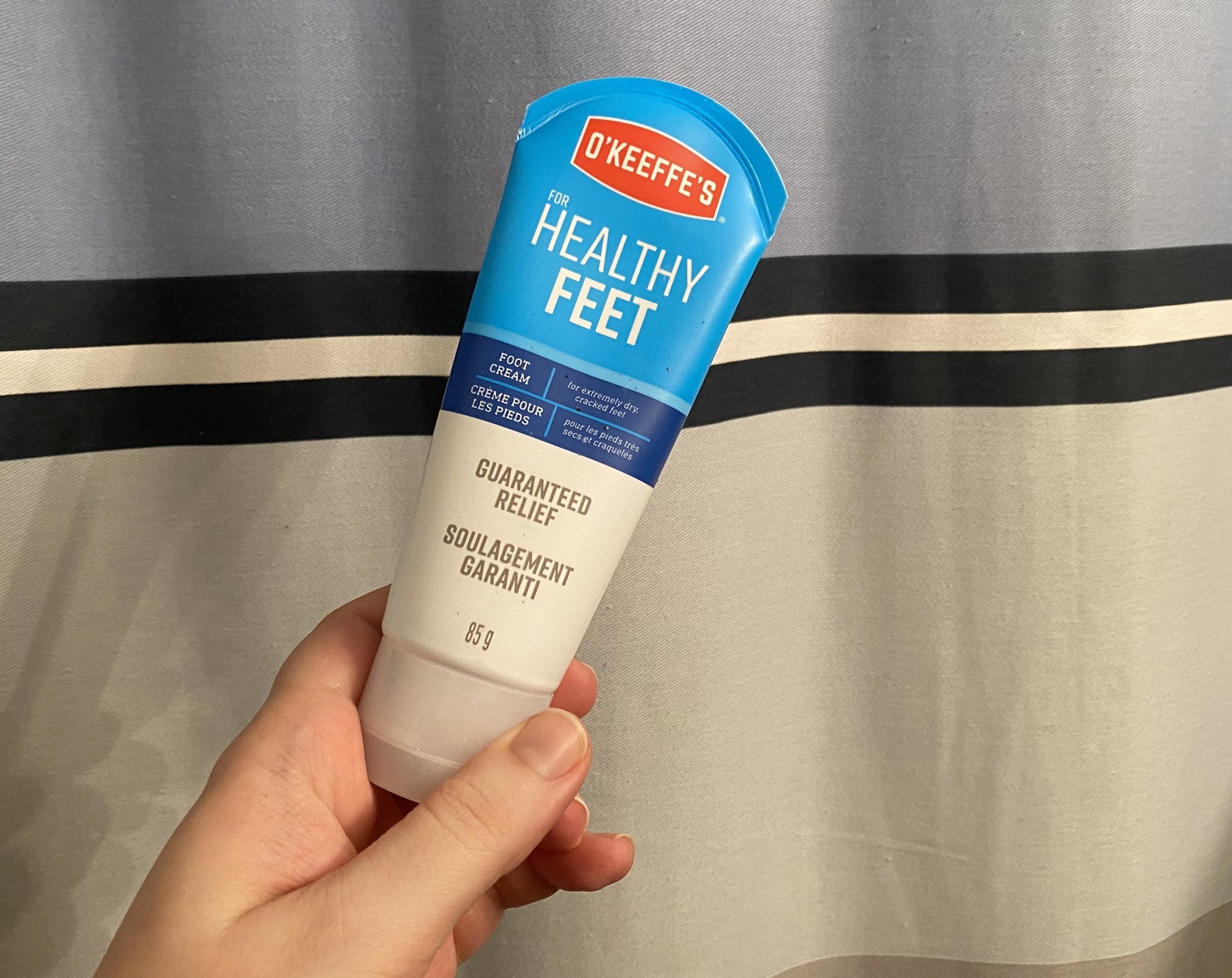 Kat holding a tube of O&#x27;Keefe&#x27;s Healthy Feet foot cream