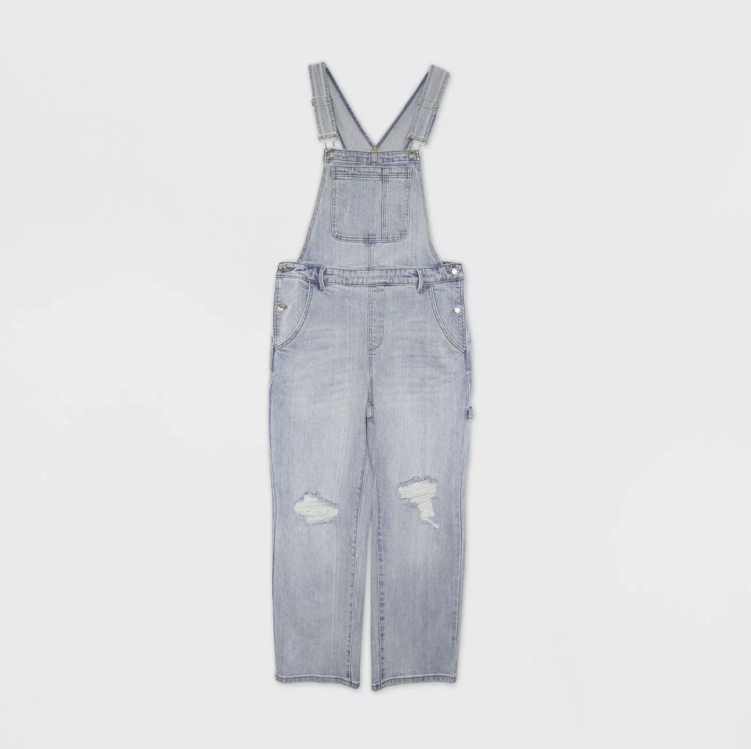 A light wash denim overall with frayed rips on the knees