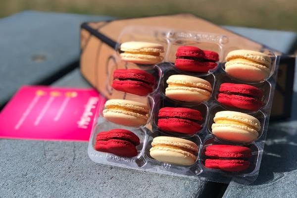 A container of 12 macarons, there are two flavors and six of each of those flavors