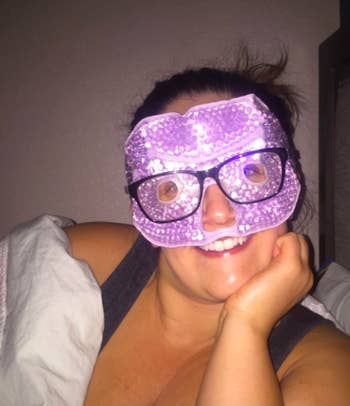 A reviewer wearing the purple, gel bead-filled mask under their glasses