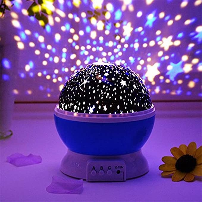 A projector lamp with tiny stars and planets on it.