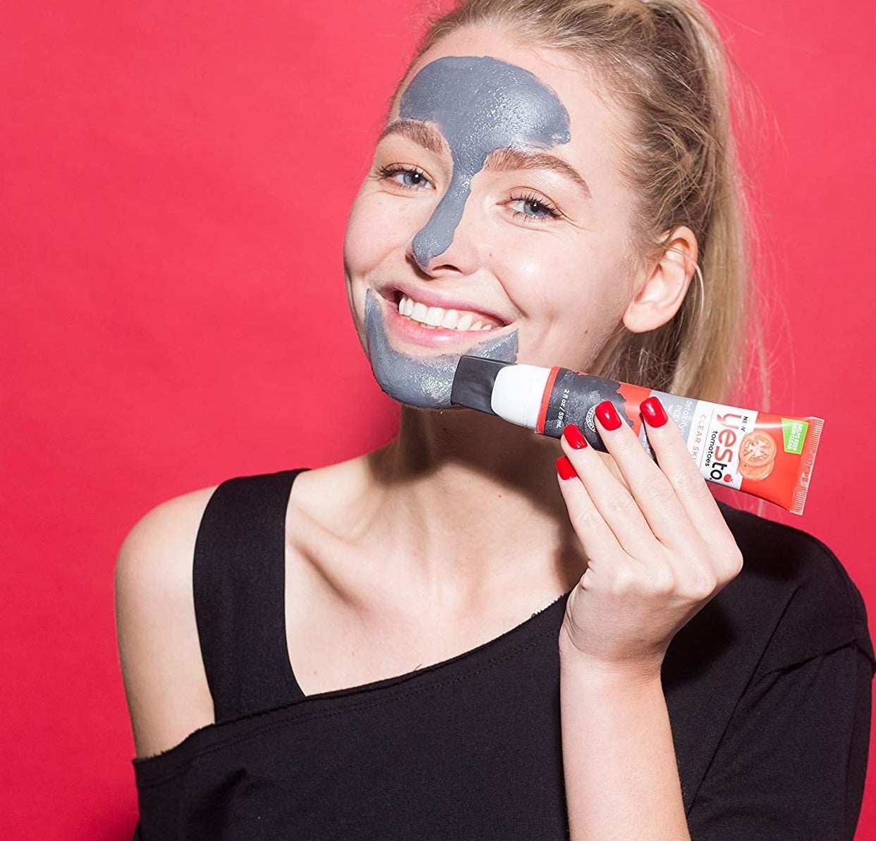 A person using the silicone tip to apply the product to their face