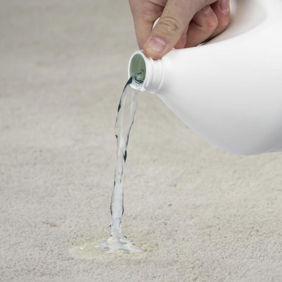 Hand pouring the detergent onto a carpet stain 