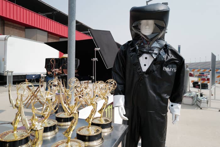 A mannequin in a hazmat suit next to Emmy trophies