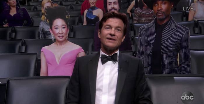 Jason sitting next to cutouts of celebrities