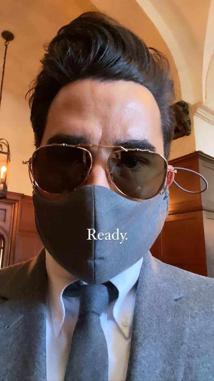 Dan Levy wearing a mask with his suit