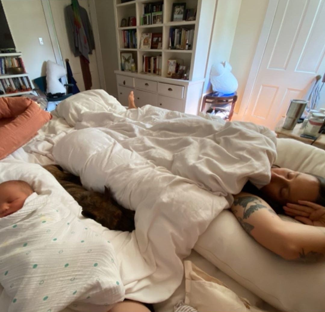 A photo of Domino Kirke sleeping alongside her newborn son and her pet