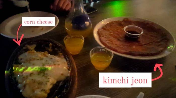 Corn cheese, kimchi jeon, and soju on a table at a Koreatown bar