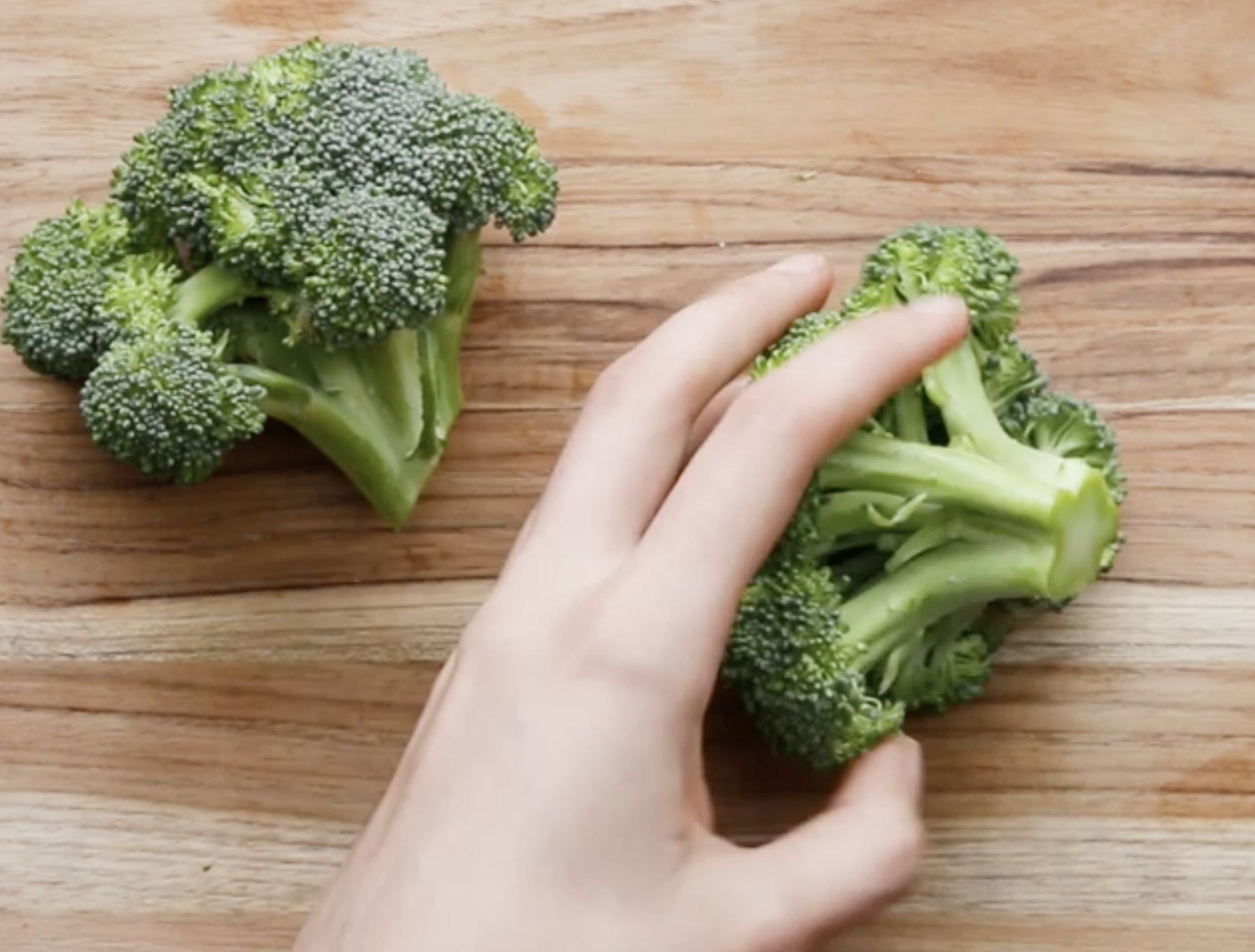 Broccoli florets on a cutting board.