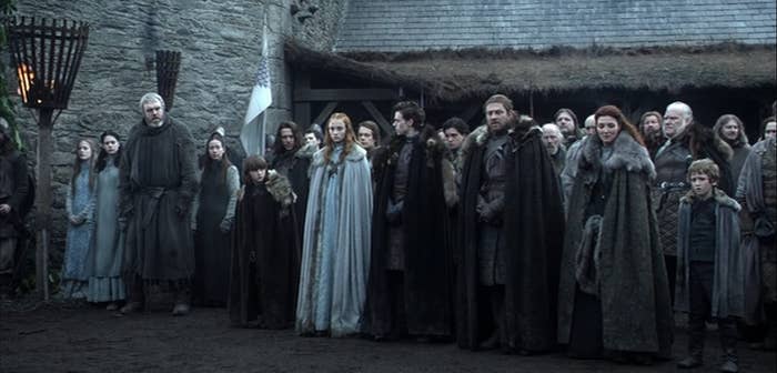Still from Game of Thrones: The Stark family stand in a row in the courtyard at Winterfell