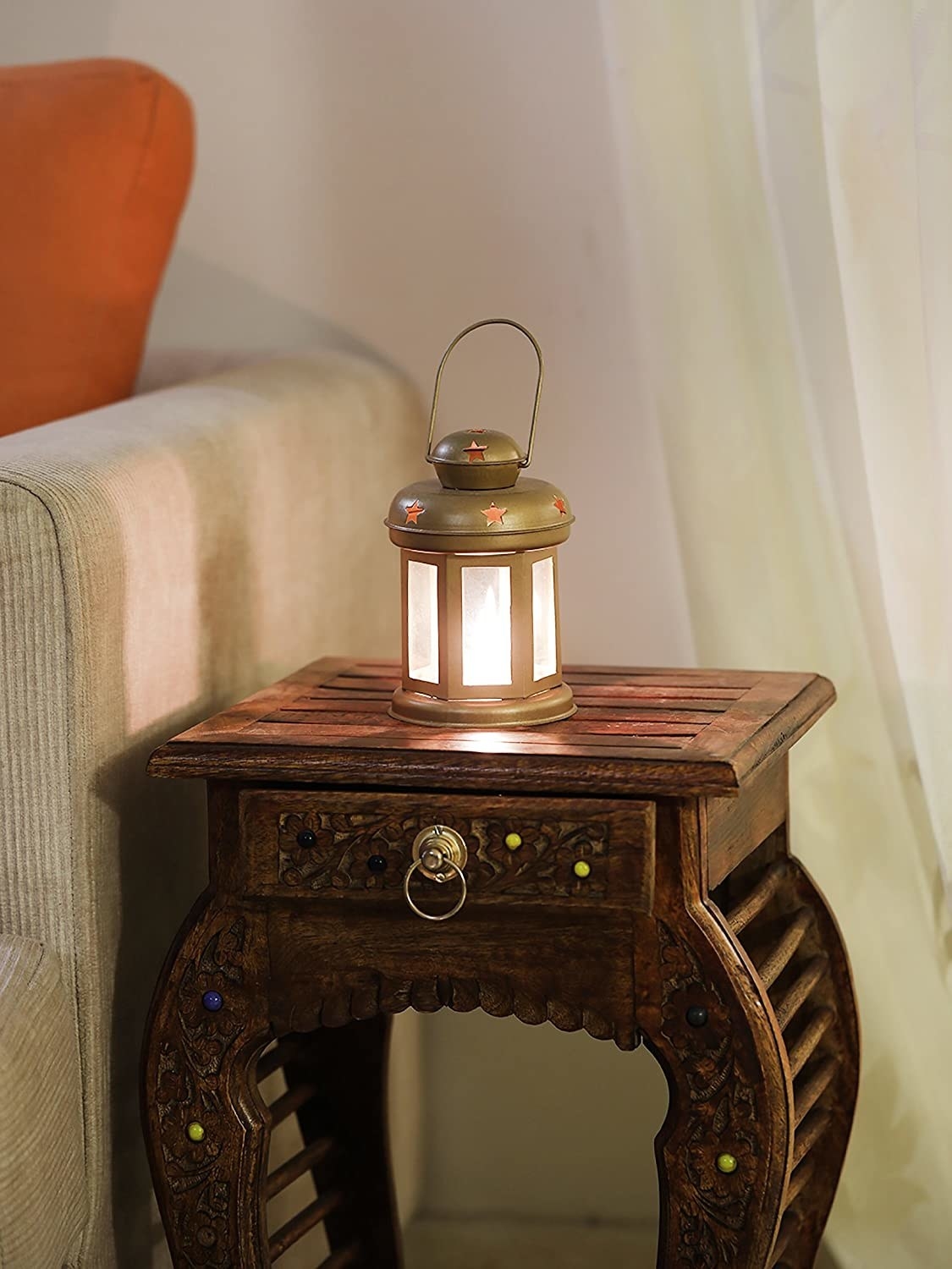 A golden lantern kept on a wooden bedside table.