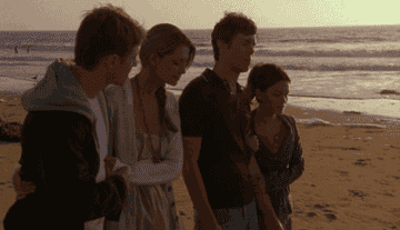 Ryan, Marissa, Seth, and Summer walk down a beach