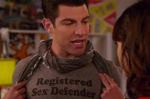 Schmidt wearing a shirt that says "registered sex defender"