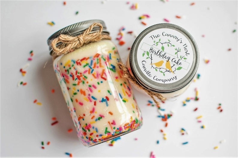The candle — it&#x27;s cream color sprinkle funfetti design and coms in a glass jar