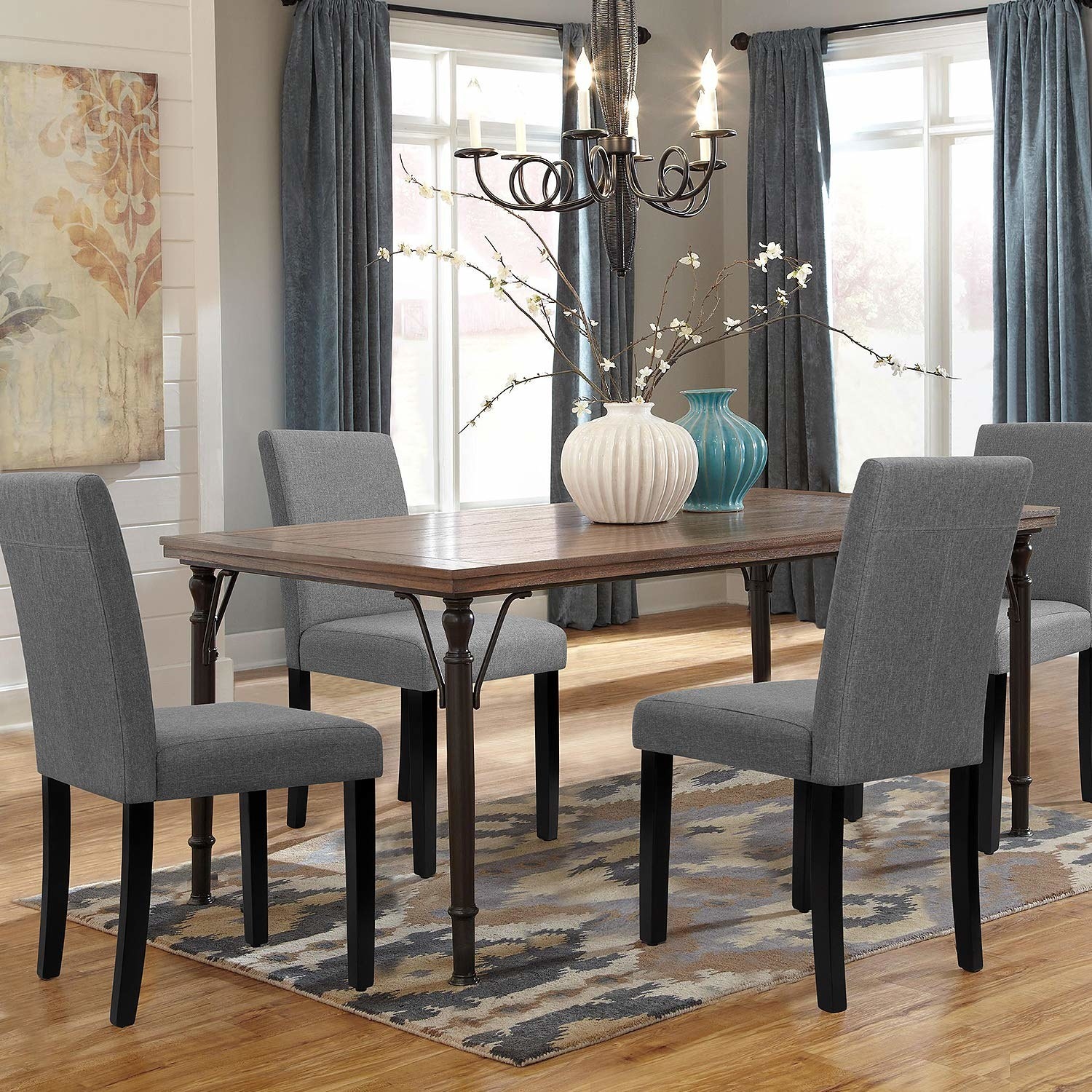 The grey chairs arranged around a large wooden table